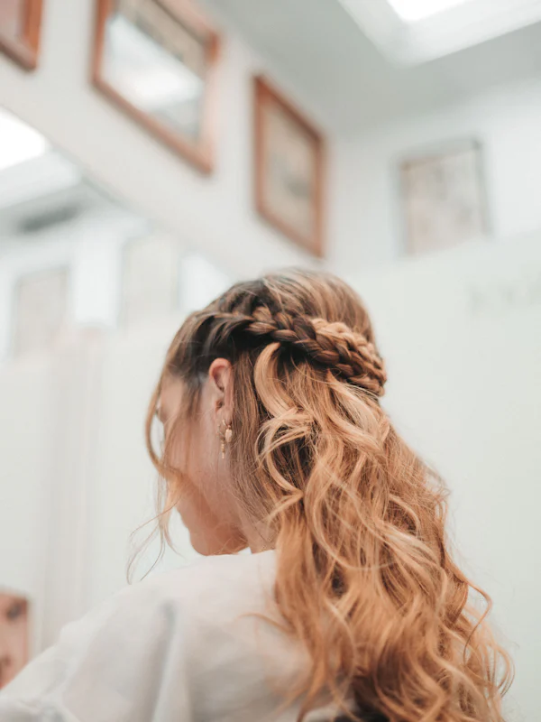 A braided half-up style on long wavy hair
